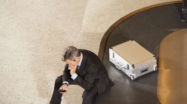 man sitting on luggage carousel