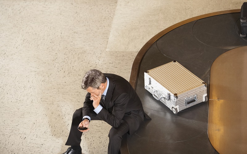 man sitting on luggage carousel